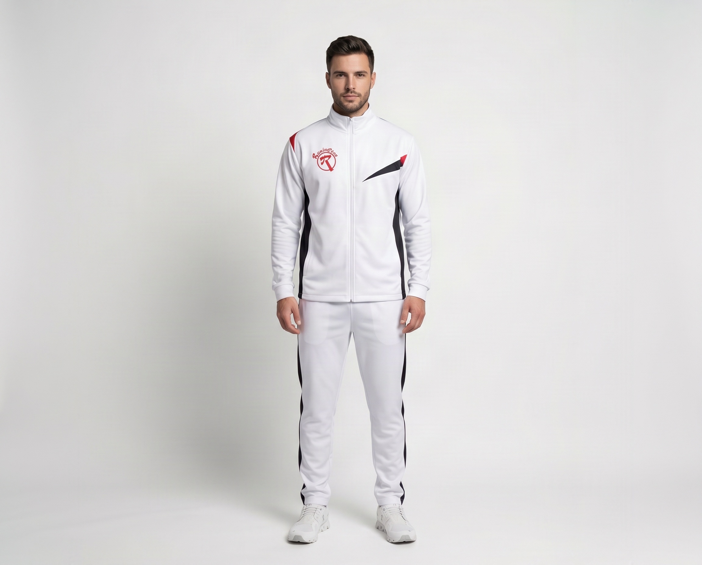 Front view of men’s white performance tracksuit with black and red contrast panels, full-zip jacket and matching training pants.