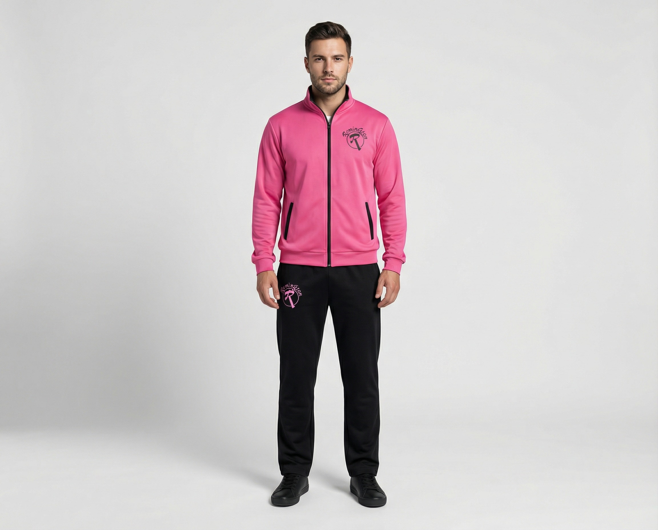 Male model wearing a bright pink full-zip tracksuit jacket with black zipper, black side pockets and matching black athletic pants