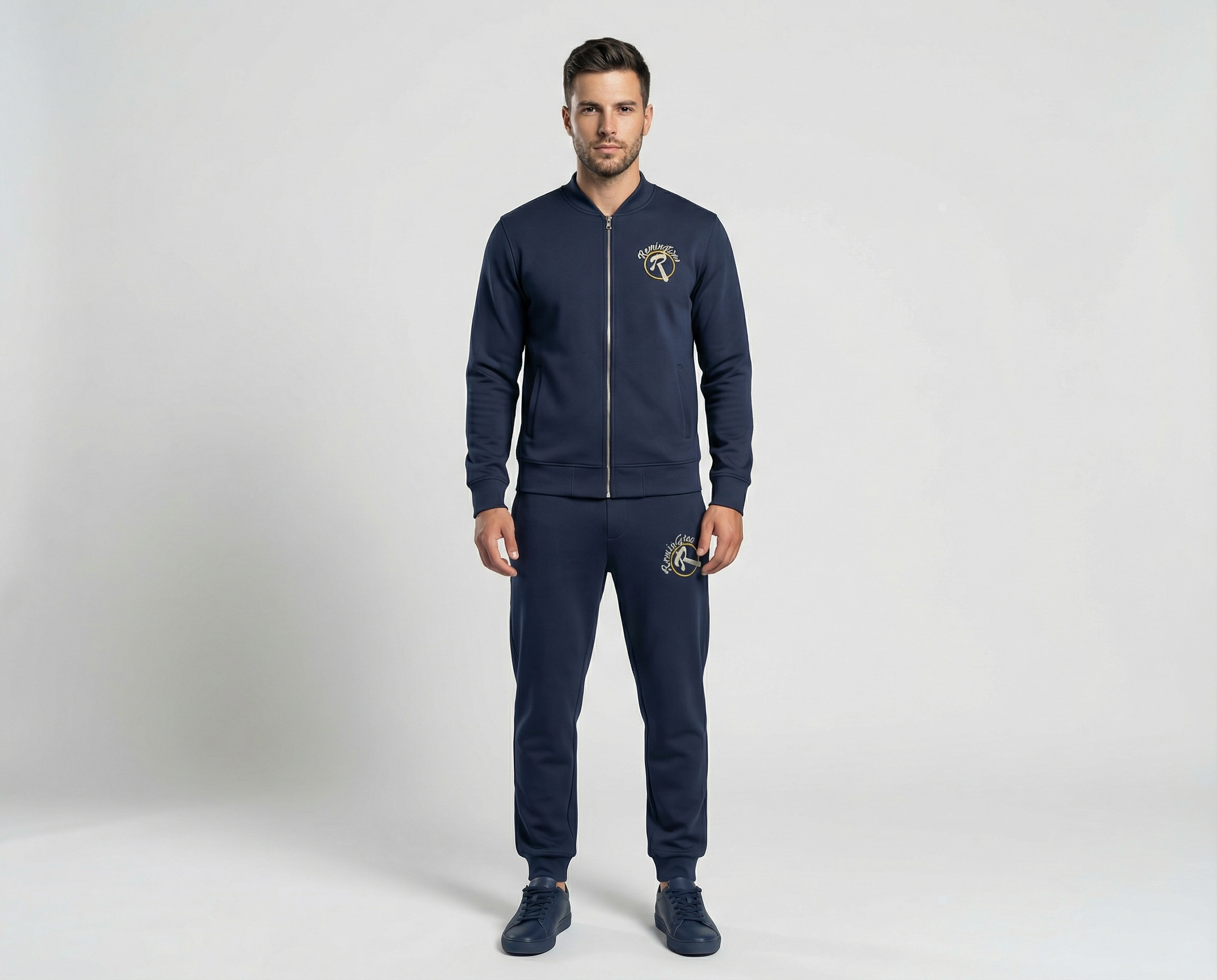 Front view of men's navy blue tracksuit with bomber-style collar, full-length zipper, gold chest logo and matching joggers