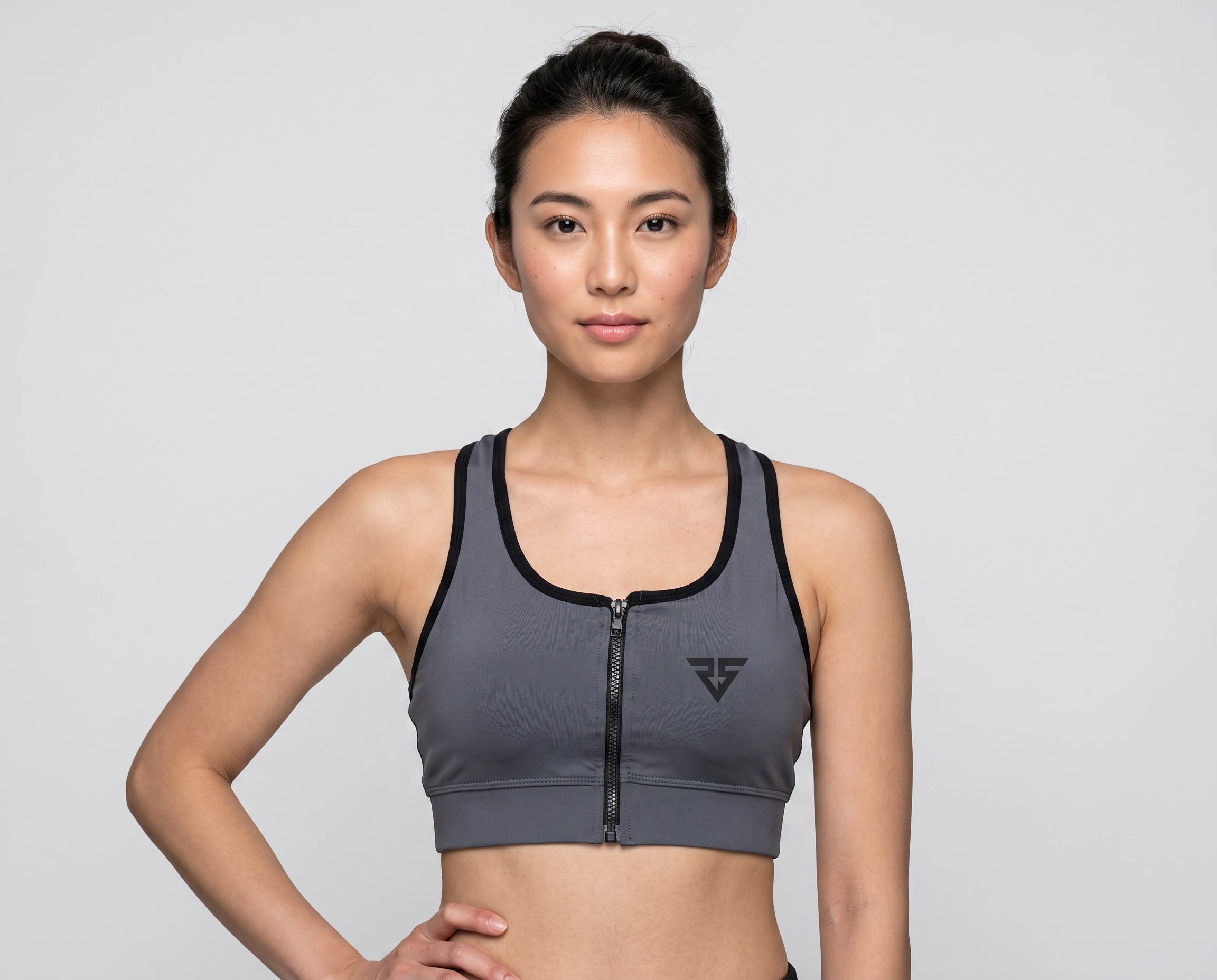 Women’s charcoal grey front zip sports bra with black contrast binding and racerback design.