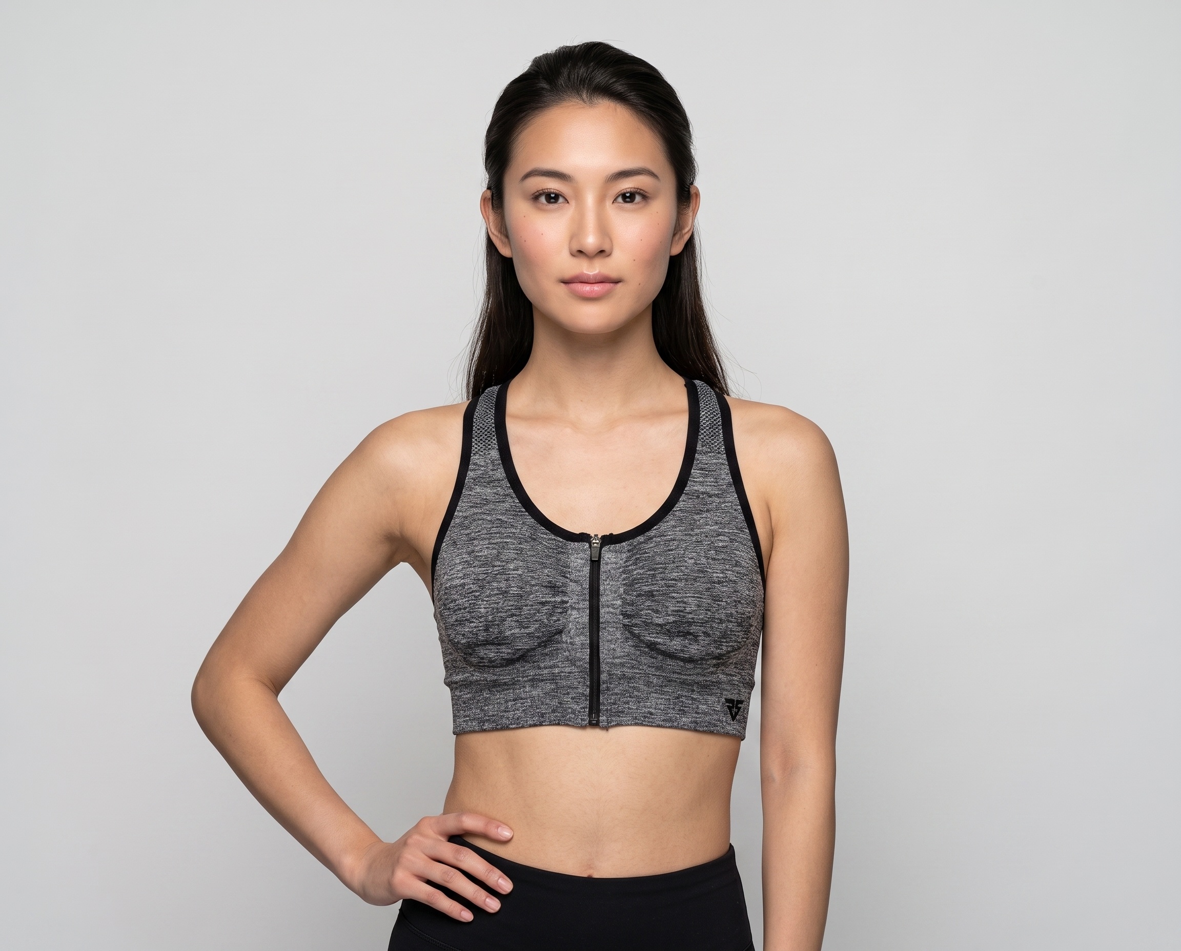 Women’s heather grey front zip sports bra with black contrast binding and supportive athletic fit.