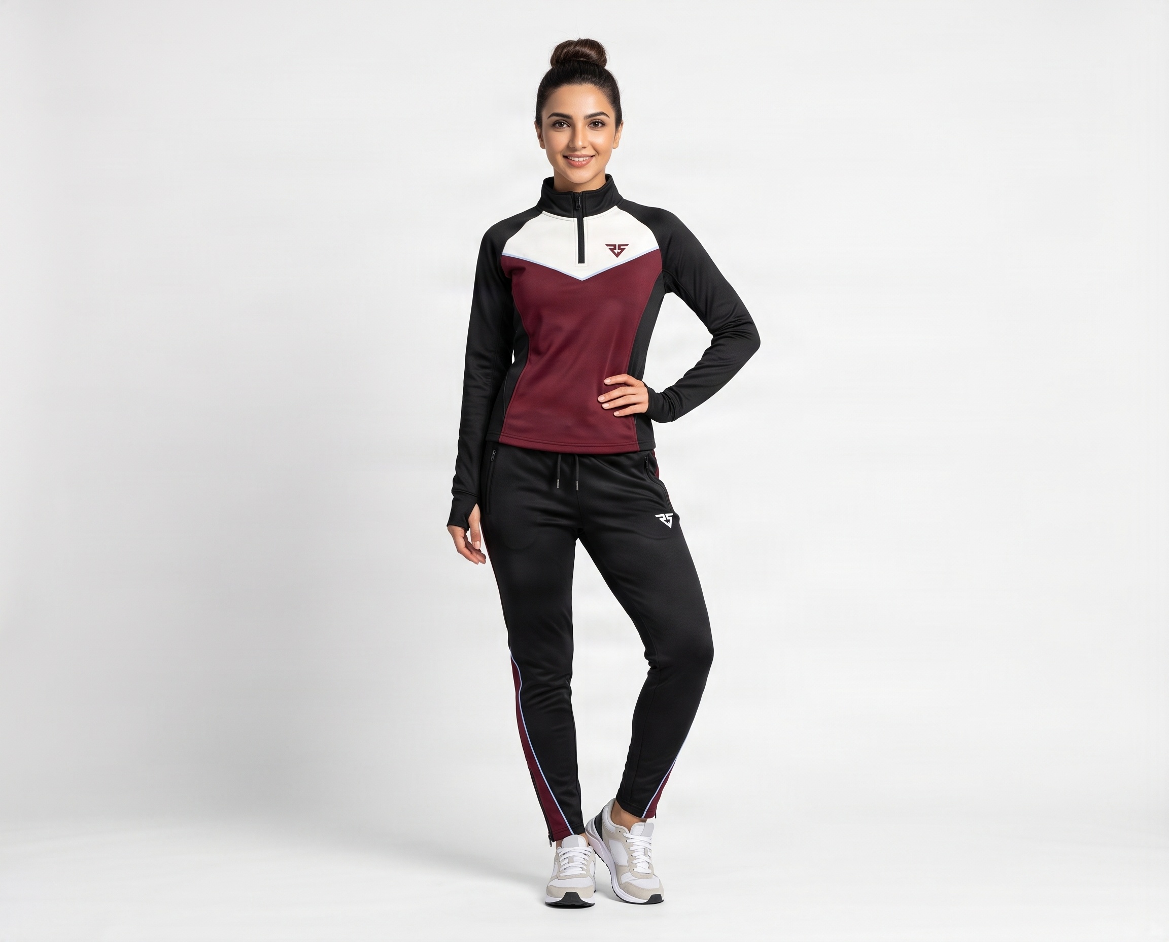 Front view of women’s black and maroon performance tracksuit with quarter-zip top and thumbhole cuffs
