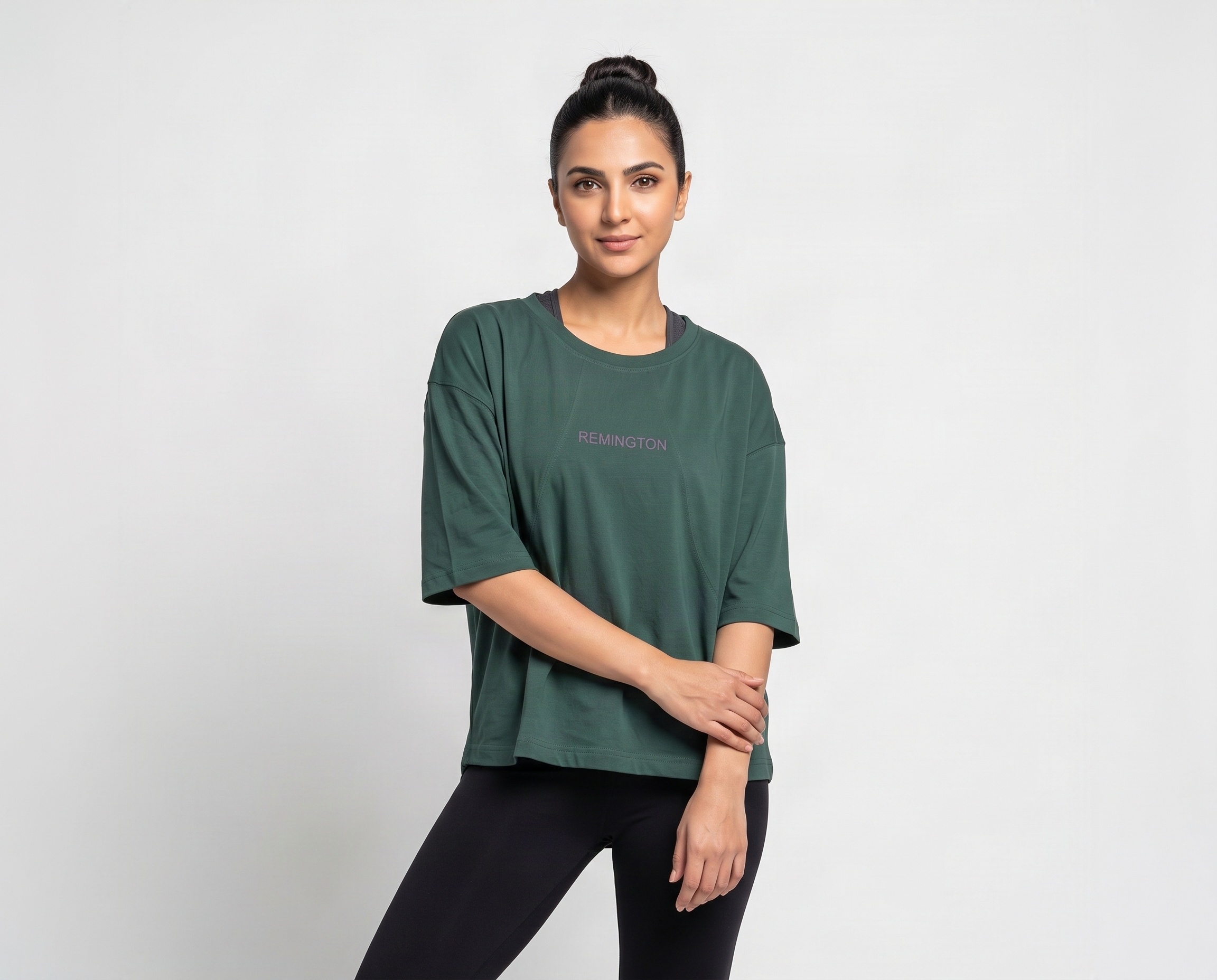 Front view of women's forest-green oversized crew-neck T-shirt with minimal Remington branding